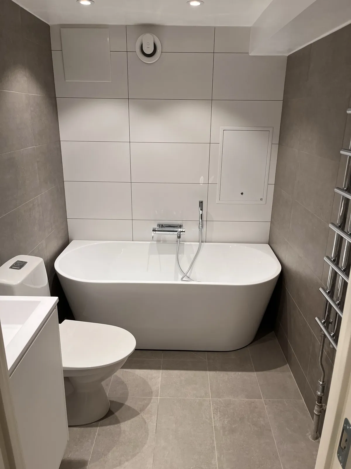 Badrumsrenovering Harplinge – Fristående badkar på grå klinker med handdukstork